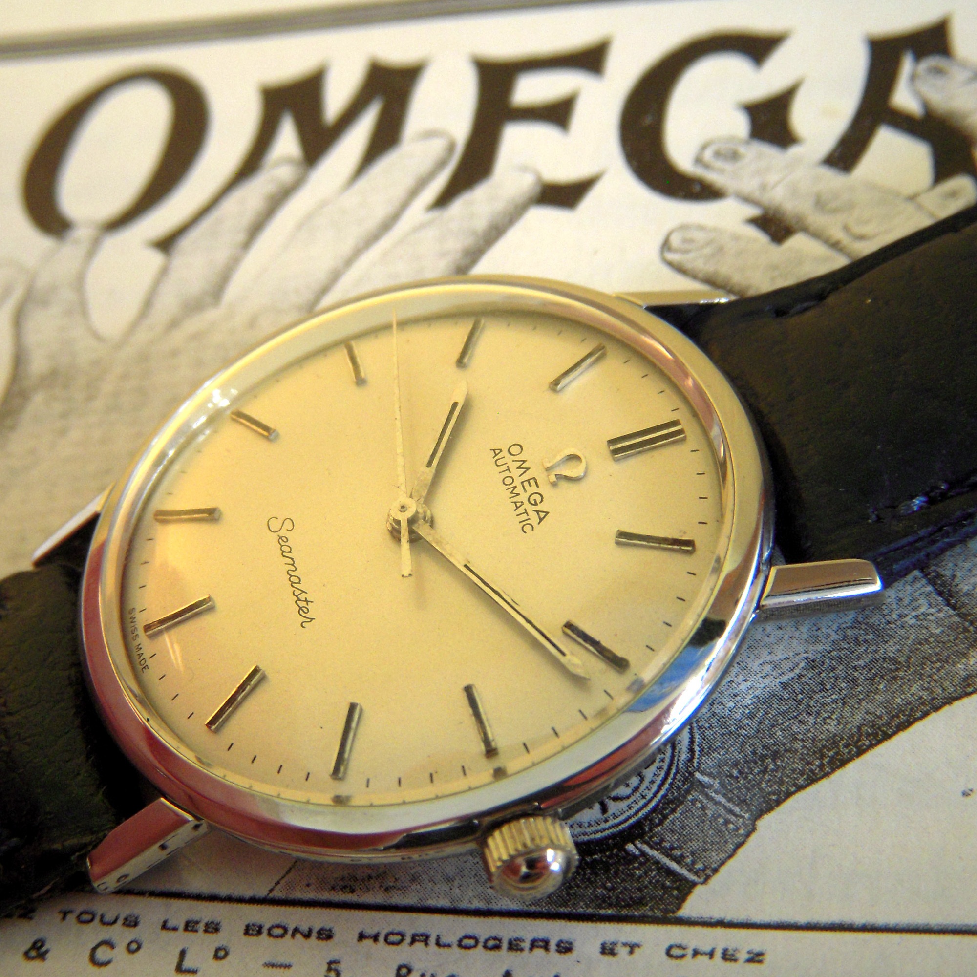 Vintage Omega Seamaster automatic on a period Omega advertisement